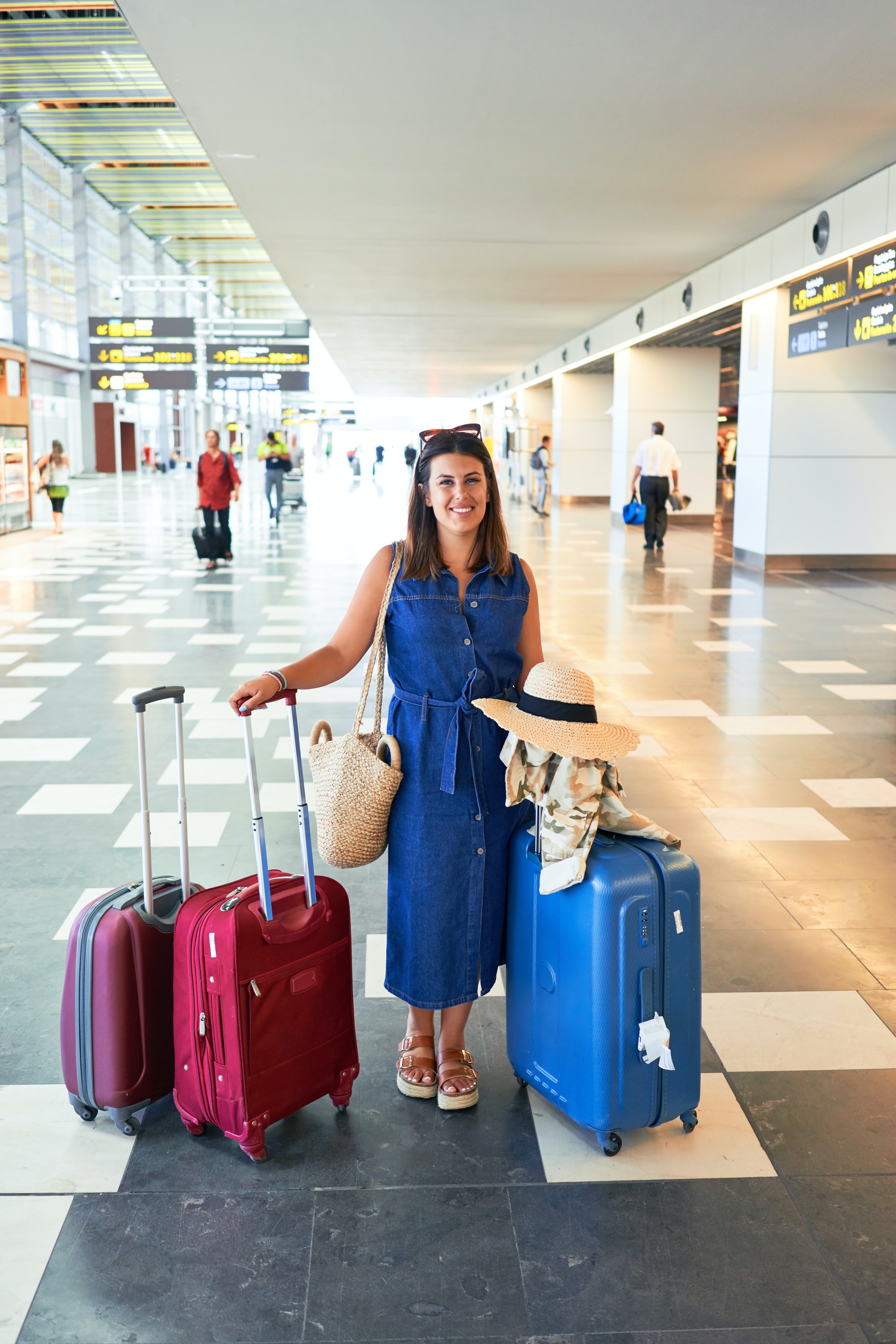 woman at the airport with three rolling suitcases